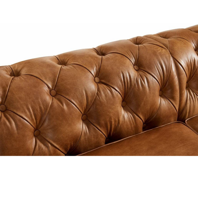 Brown leather sofa with tufted backrest on a white background