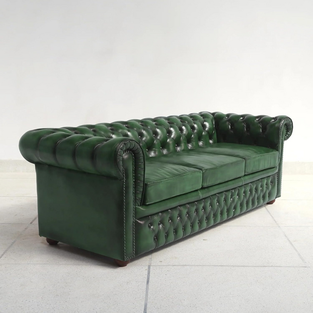Green tufted sofa on a white background