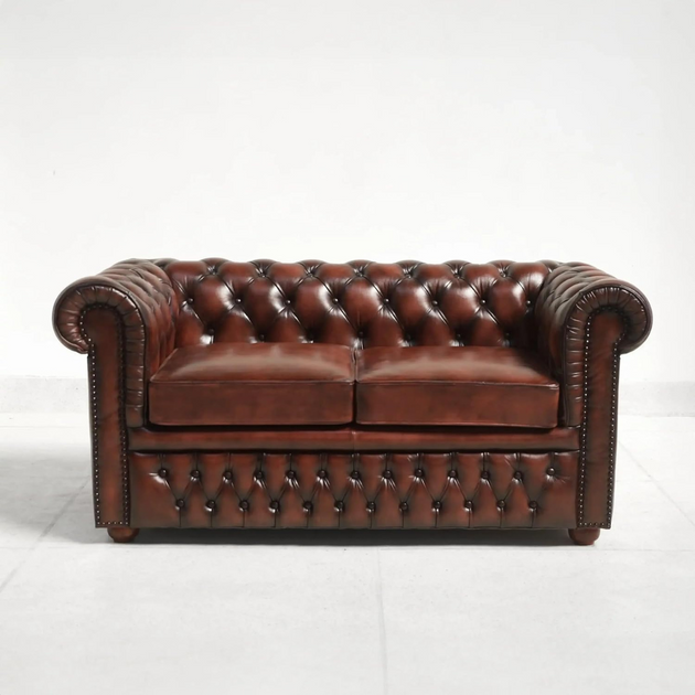 Brown leather sofa with tufted backrest on a white background