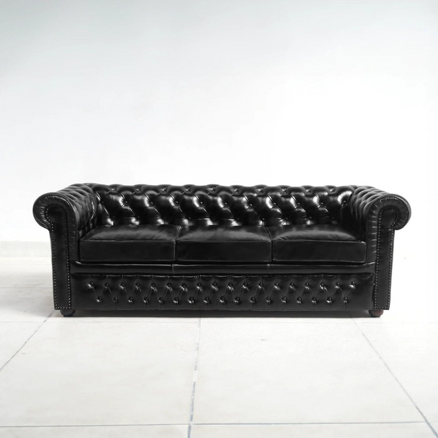 Black leather sofa on a white floor and background