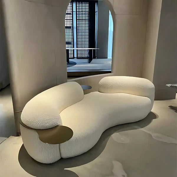 Modern white sofa in a minimalistic room with a textured wall and floor.