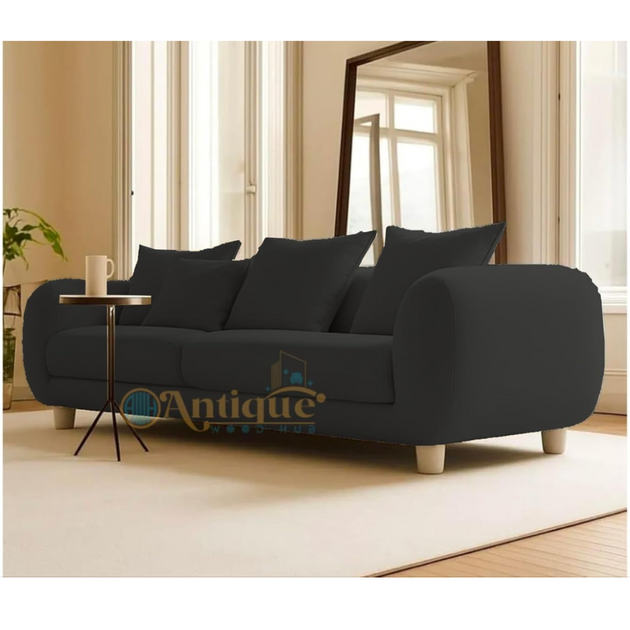 Black sofa in a living room with a 'Antique' logo in the corner.