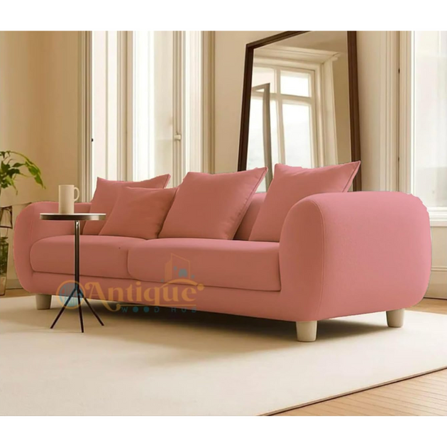 Pink sofa with cushions in a living room setting, featuring the brand 'Antique'.