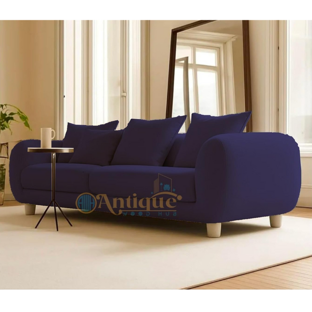 Blue sofa with cushions in a room with large windows and a mirror.