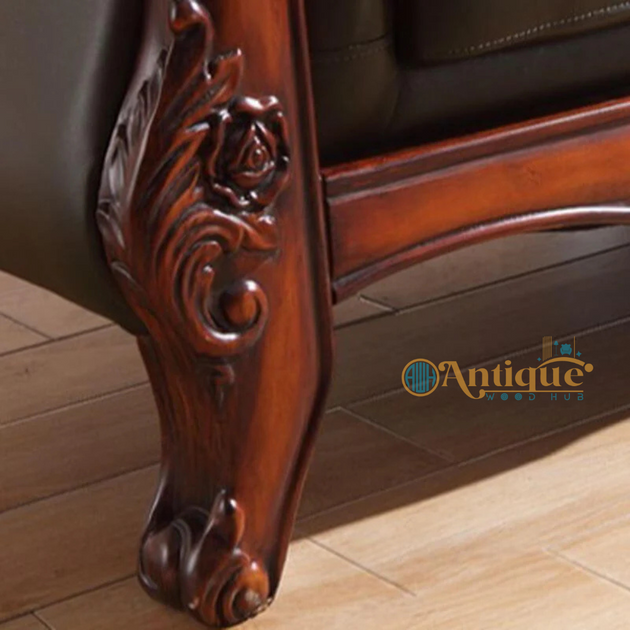 Close-up of an ornate wooden leg on a piece of furniture with 'Antique' branding.