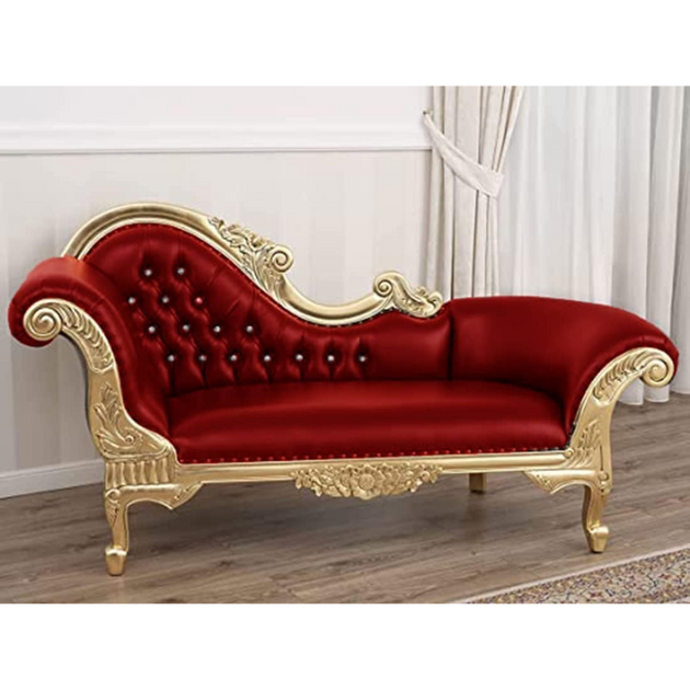 Red velvet chaise lounge with gold frame on a wooden floor.