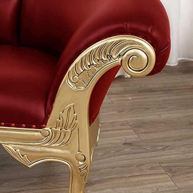 Red armchair with gold decorative armrest on a wooden floor