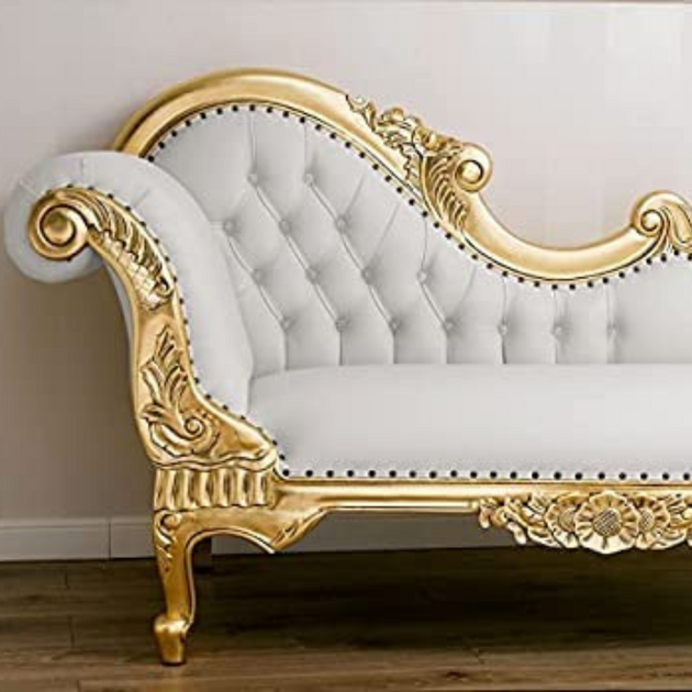 Decorative white sofa with gold ornate frame against a plain background