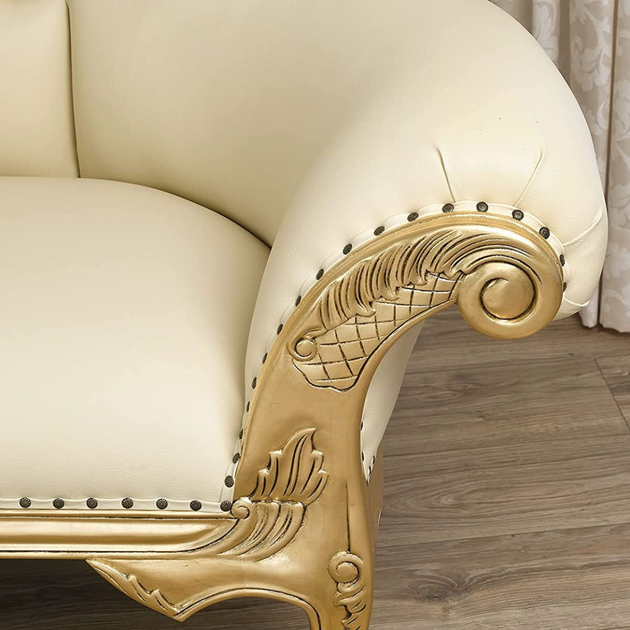 Beige sofa with ornate gold armrest on a wooden floor