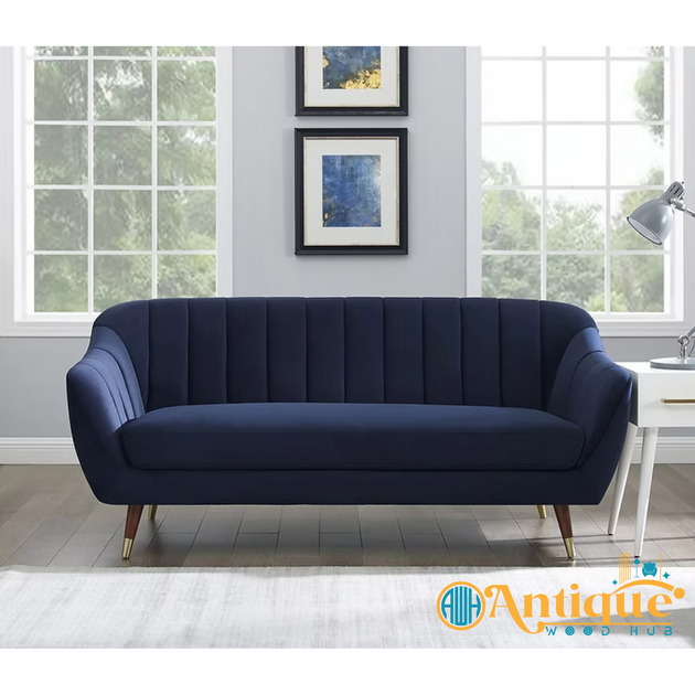 Navy blue sofa in a room with large windows and framed pictures on the wall.
