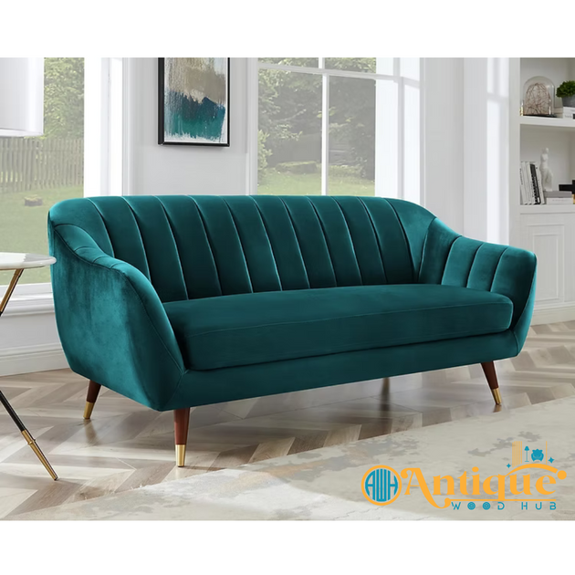 Teal sofa in a room with large windows and a visible brand logo.