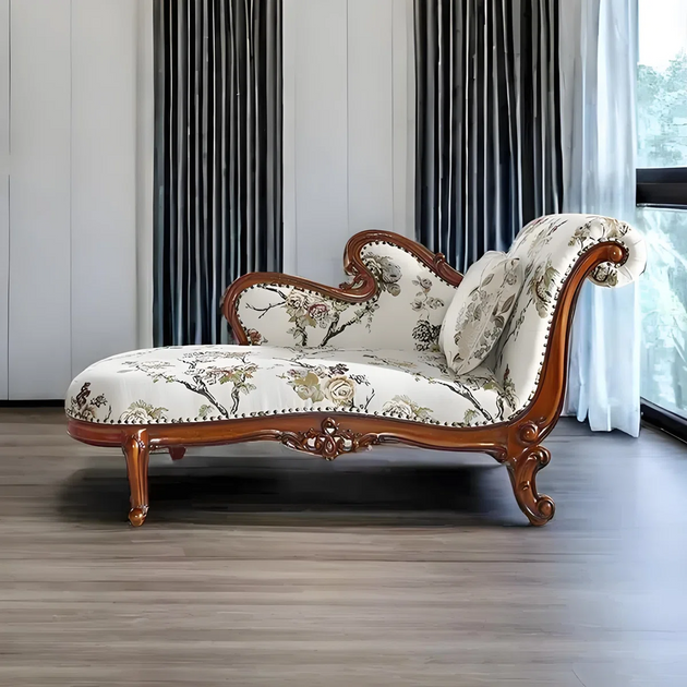 Decorative chaise lounge with floral pattern in a room with curtains and a window.