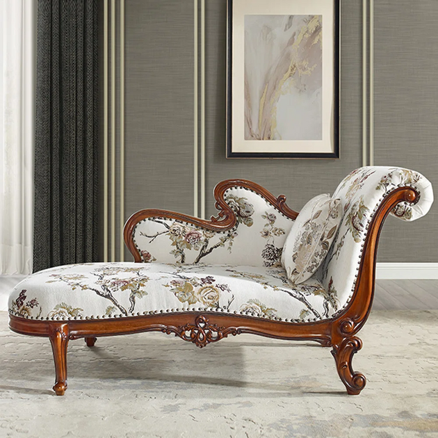 Decorative chaise lounge with floral pattern and wooden frame in a room setting.